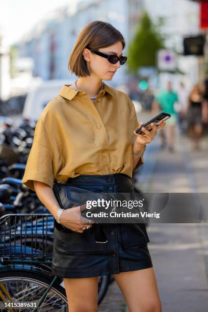 Jacqueline Zelwis is seen wearing brown button shirt, black skirt, black Copenhagen Studios bag on August 11, 2022 in Copenhagen, Denmark.