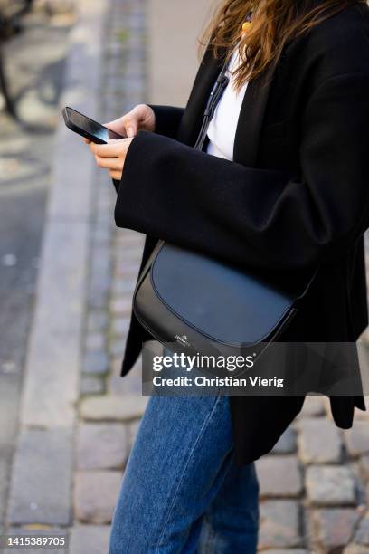 Isis-Maria Niedecken is seen wearing black Copenhagen Studios bag, denim jeans, black blazer on August 11, 2022 in Copenhagen, Denmark.