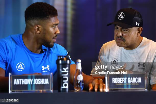 Anthony Joshua talks with their trainer, Robert Garcia during the Rage on the Red Sea Press Conference at Shangri-La Hotel on August 17, 2022 in...