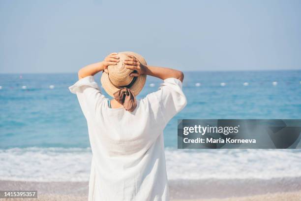 happy woman relaxing at the beach. - zonnehoed stockfoto's en -beelden