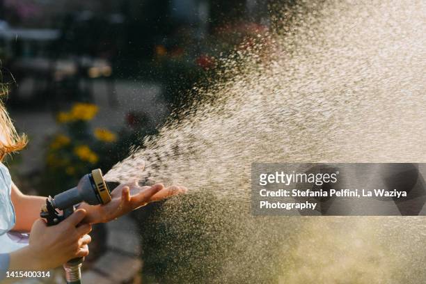 child's hands holding a hose - water wastage stock pictures, royalty-free photos & images