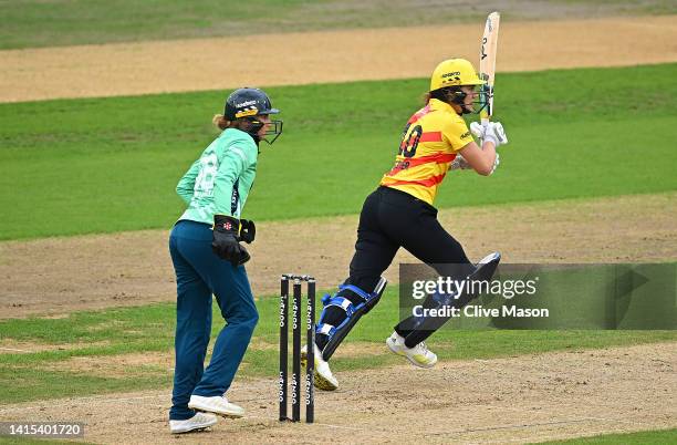 Nat Sciver of Trent Rockets hits out as Lauren Winfield-Hill of Oval Invincibles looks on during The Hundred match between Trent Rockets Women and...