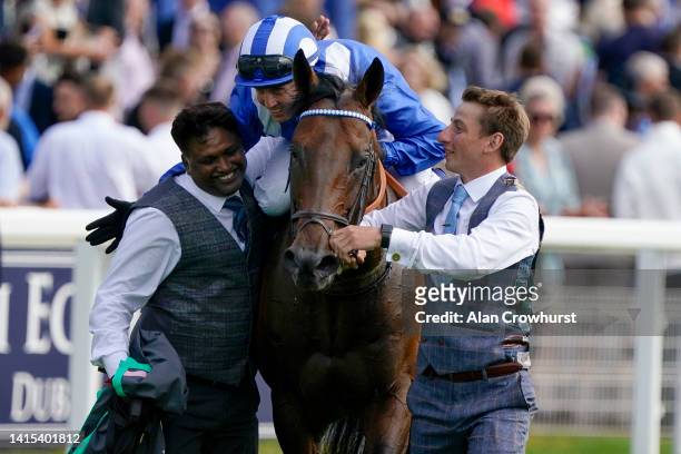 Stable lads congratulate Jim Crowley after he rides Baaeed to win The Juddmonte International Stakes at York Racecourse on August 17, 2022 in York,...