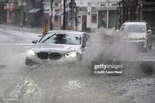 Car negotiates a flooded section of road, as torrential rain and thunderstorms hit the country on August 17, 2022 in London, England. After the UK...