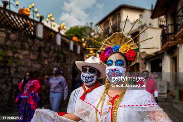 Young Mexican woman, dressed as La Catrina and wearing an embroidered face mask, performs during the Day of the Dead celebrations on October 29, 2021...