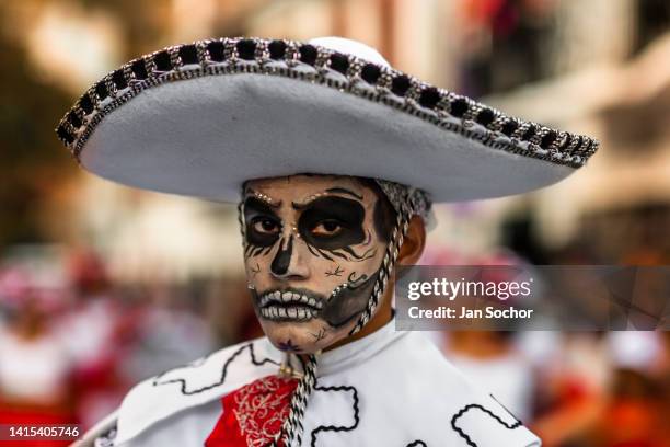 Mexican man, with a face painted as Catrin and wearing a Mariachi sombrero hat, performs during the Day of the Dead celebrations on October 30, 2021...