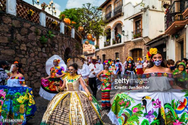 Mexican women, dressed as La Catrina, a Mexican pop culture icon representing the Death, dance in the Day of the Dead parade on October 29, 2021 in...