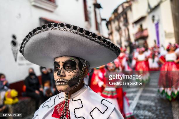 Mexican man, with a face painted as Catrin and wearing a Mariachi sombrero hat, performs during the Day of the Dead celebrations on October 30, 2021...