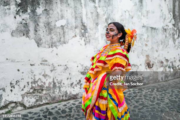 Mexican girl, dressed as La Catrina, a Mexican pop culture icon representing the Death, dances during the Day of the Dead celebrations on October 30,...
