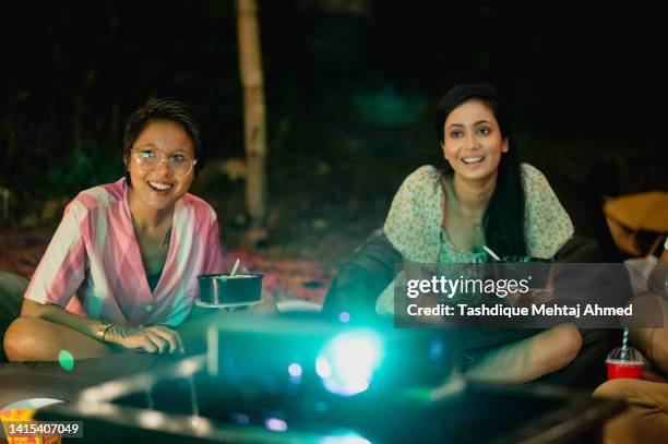 group of friends enjoying a movie outdoors. - projector stock pictures, royalty-free photos & images