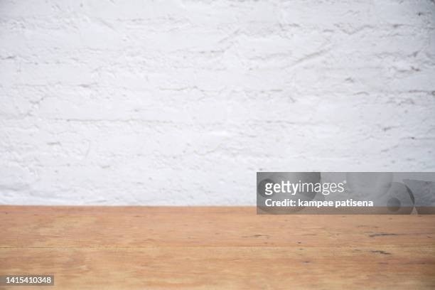 empty wood table top, counter, desk with white brick wall background - table brick wall wood stock-fotos und bilder