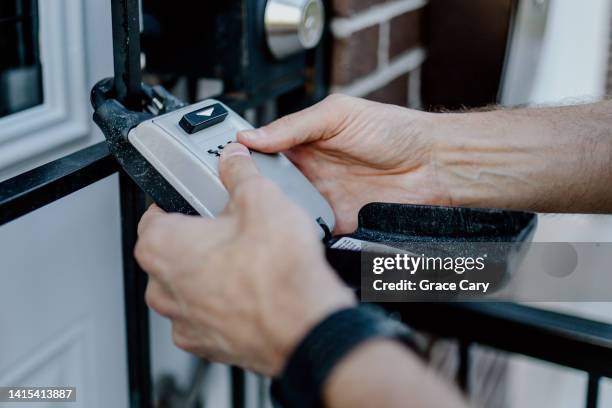 real estate agent opens lockbox to access house key - safe lock stock pictures, royalty-free photos & images