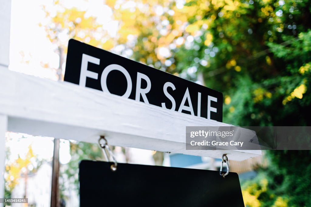 For Sale Sign in Front Yard of House