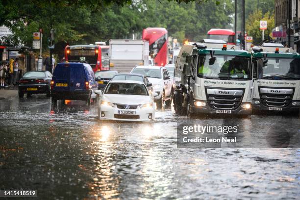 Car negotiates a flooded section of road, as torrential rain and thunderstorms hit the country on August 17, 2022 in London, England. After the UK...