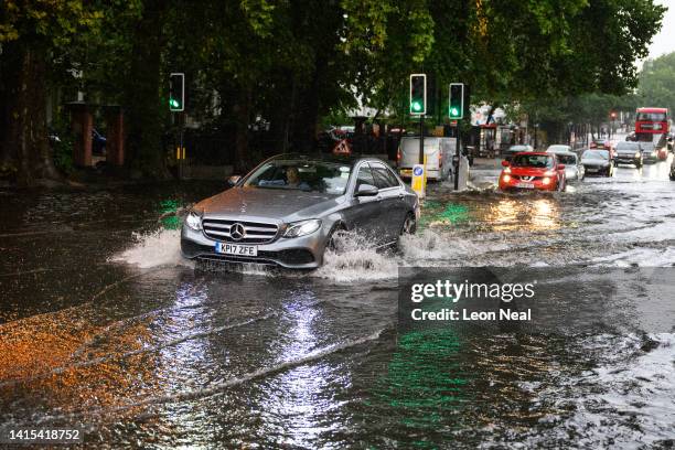 Car negotiates a flooded section of road, as torrential rain and thunderstorms hit the country on August 17, 2022 in London, England. After the UK...