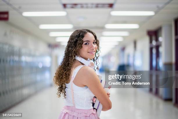 female high school student walking in school hallway - music halls fotografías e imágenes de stock