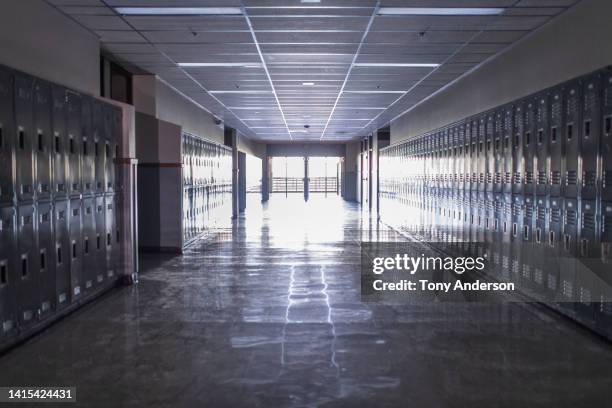empty high school corridor with lockers lining the walls - escuela fotografías e imágenes de stock