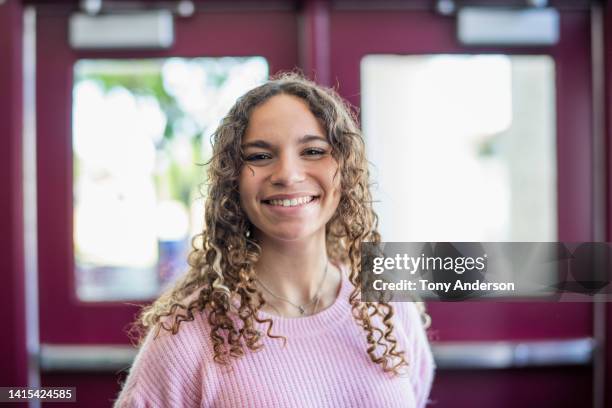 portrait of teenage girl in high school entryway - 14 year old biracial girl curly hair stock pictures, royalty-free photos & images