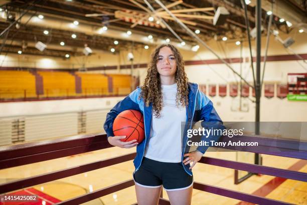 portrait of female high school basketball player in gymnasium - sekundarschule stock-fotos und bilder