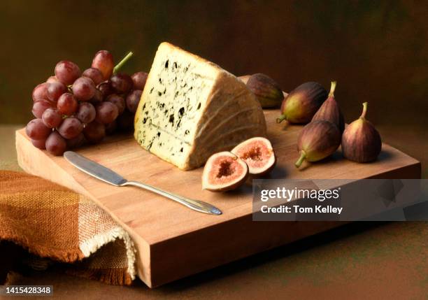 blue cheese with grapes and figs - stilton stock-fotos und bilder