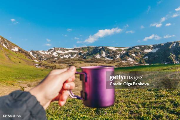 human hand with a camping cup on a mountain background . personal perspective, pov. - breakfast top view stock pictures, royalty-free photos & images