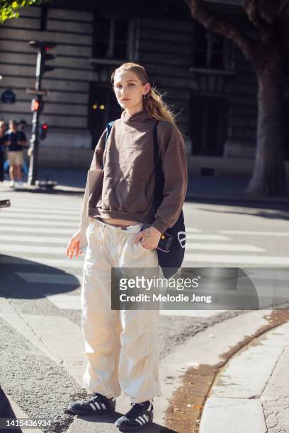 Model Jade Huber wears a brown hoodie, tan low-rise loose cargo pants, black Adidas Samba sneakers after the Patou show during Couture Fashion Week...
