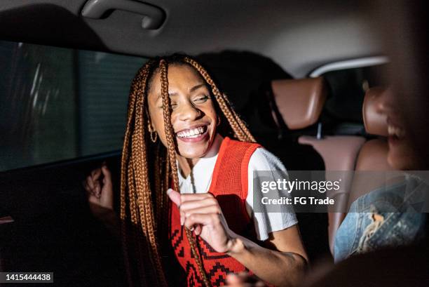 young woman laughing with a friend in the car - car passenger stock pictures, royalty-free photos & images