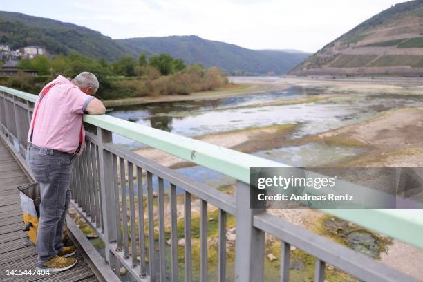 Man looks at the almost dried up Rhine River on August 17, 2022 in Bingen am Rhein, Germany. The ongoing hot weather and lack of rain have caused...