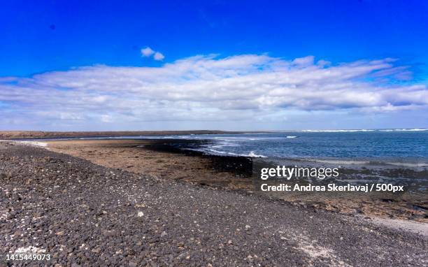 scenic view of beach against blue sky - viaggio di nozze stock pictures, royalty-free photos & images