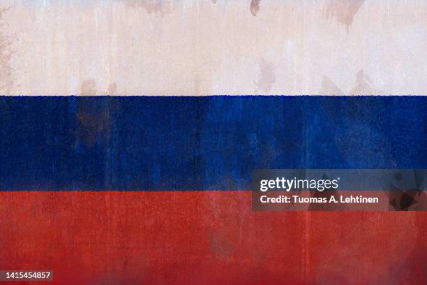 full frame front view photo of a weathered flag of russia painted on a rusty, grunge and dirty wall. - russia flag stock pictures, royalty-free photos & images