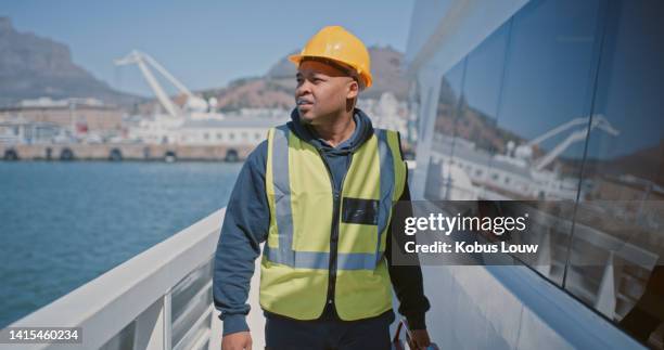 seaman, engineer and ship mechanic doing maintenance, inspection and repairs while wearing a hardhat and reflective vest. marine worker, supervisor or manager looking at ocean while doing rounds - studying hard stock pictures, royalty-free photos & images