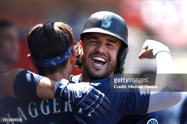 Eugenio Suarez of the Seattle Mariners celebrates with his teammate Sam Haggerty after hitting a two run home run against the Los Angeles Angels...