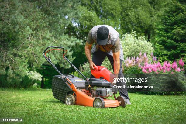 mature adult man mows the grass in the garden with a lawn mower - grass cut out stock pictures, royalty-free photos & images