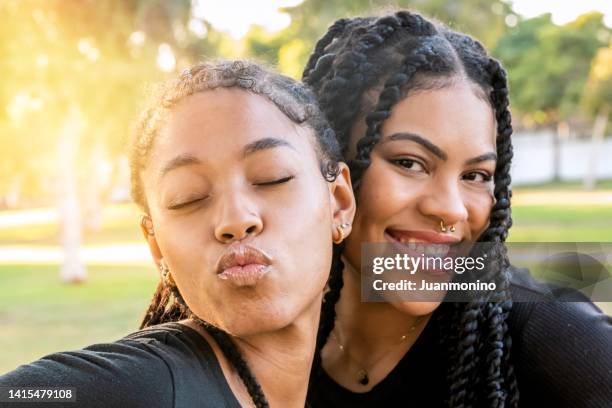 カメラを見つめながらポーズをとる笑顔の若いレズビアン女性 - depth of field togetherness looking at the camera ストックフォトと画像