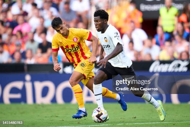 Yunus Musah of Valencia CF runs with the ball whilst under pressure from Ramon Terrats of Girona FC during the LaLiga Santander match between...