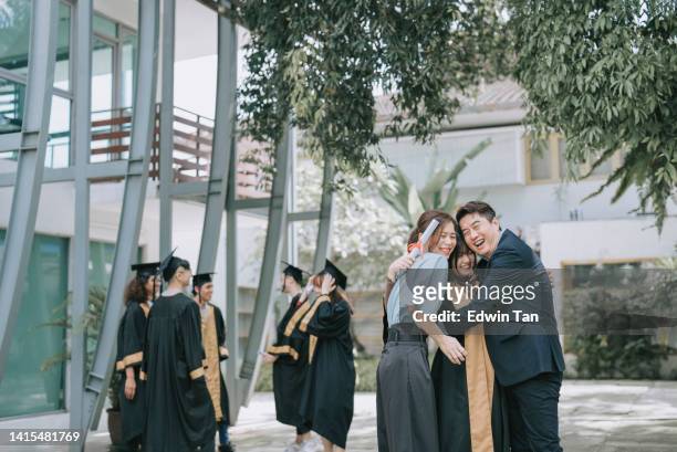 proud asian chinese parents with their daughter in college graduation gown outside college buildings - parent student stock pictures, royalty-free photos & images