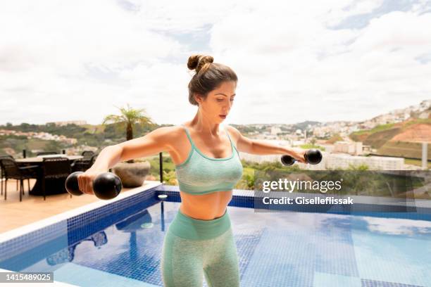 fit young woman working out with dumbbells outside in summer - dumbbell stock pictures, royalty-free photos & images