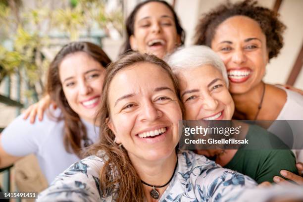 laughing group of diverse women taking selfies together outside - beautiful woman 40s stock pictures, royalty-free photos & images