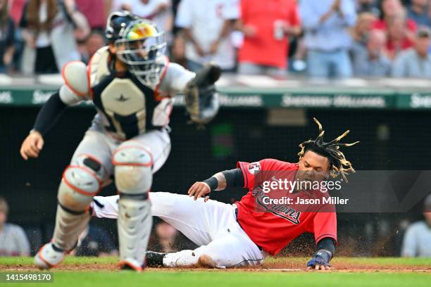 Catcher Eric Haase of the Detroit Tigers waits for the throw as Jose Ramirez of the Cleveland Guardians scores during the third inning at Progressive...