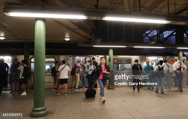 People wait to board a 1 subway train at the Columbus Circle - 59th Street station on August 17 in New York City.