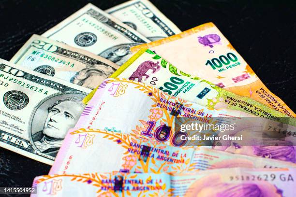 cash dollars and argentine pesos. banknotes of different values. - eva perón stock pictures, royalty-free photos & images