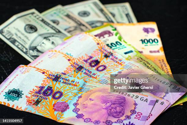 cash dollars and argentine pesos. banknotes of different values. - eva perón stock pictures, royalty-free photos & images