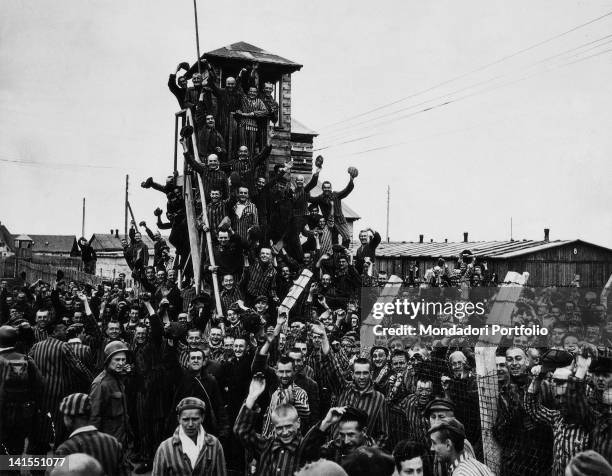 Prisoners at German Concentration Camp wave to the soldiers of the Seventh U.S. Army coming to liberate them. Dachau, 30th April 1945