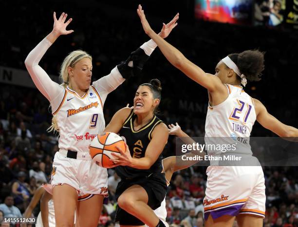 Kelsey Plum of the Las Vegas Aces is fouled by Sophie Cunningham of the Phoenix Mercury as Brianna Turner of the Mercury defends in the second...