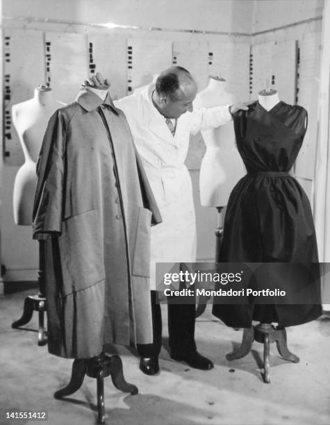 French fashion designer Christian Dior amid some dummies in his atelier. Paris, 1940s