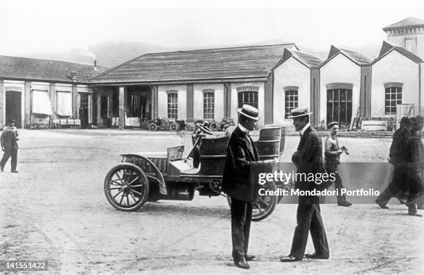 Italian enterpreneur Giovanni Agnelli, founder of FIAT car manufacturing, talking with general manager Enrico Marchesi in the courtyard of Corso...