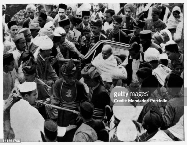 Mahatma Gandhi riding through the crowd aboard a rickshaw while going to visit British Viceroy Lord Linlithgow. Delhi, September 1940