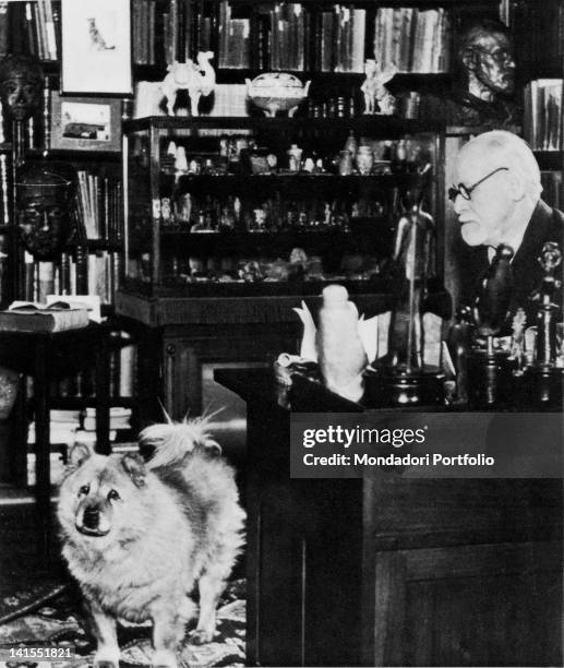 Austrian author and founder of psychoanalysis Sigmund Freud with his chow, Jofi, in his study at Berggasse 19, Vienna, Austria, circa 1937. The photo...