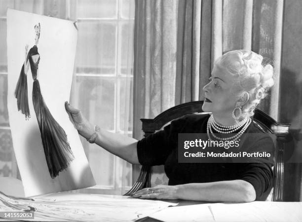 The Italian dressmaker and fashion designer looking at a sketch for a model in her Parisian atelier. Paris, 1960s