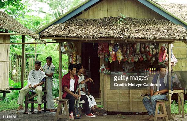 Members of a paramilitary group rest in a store May 2, 2000 in a village in Talipao, Sulu. The group is trying to prevent the escape of members of...